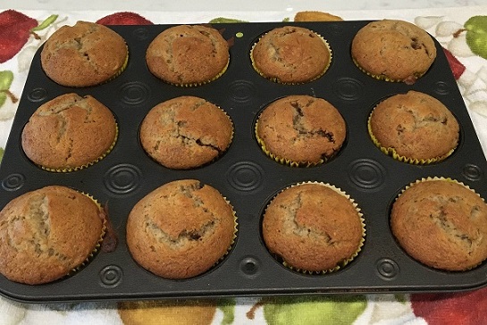 12 apple butter banana bread muffins in a muffin tin